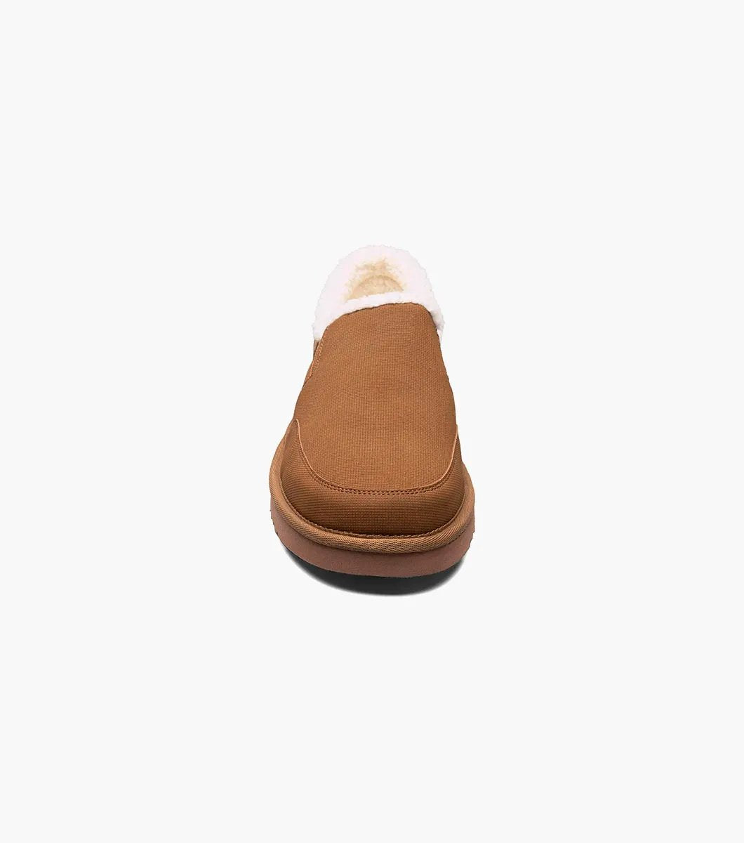 The Stacy Adams Coze Moc Toe Slip On in Tan Multi features a textured upper, plush faux shearling lining, and flat rubber sole, shown on a white background.