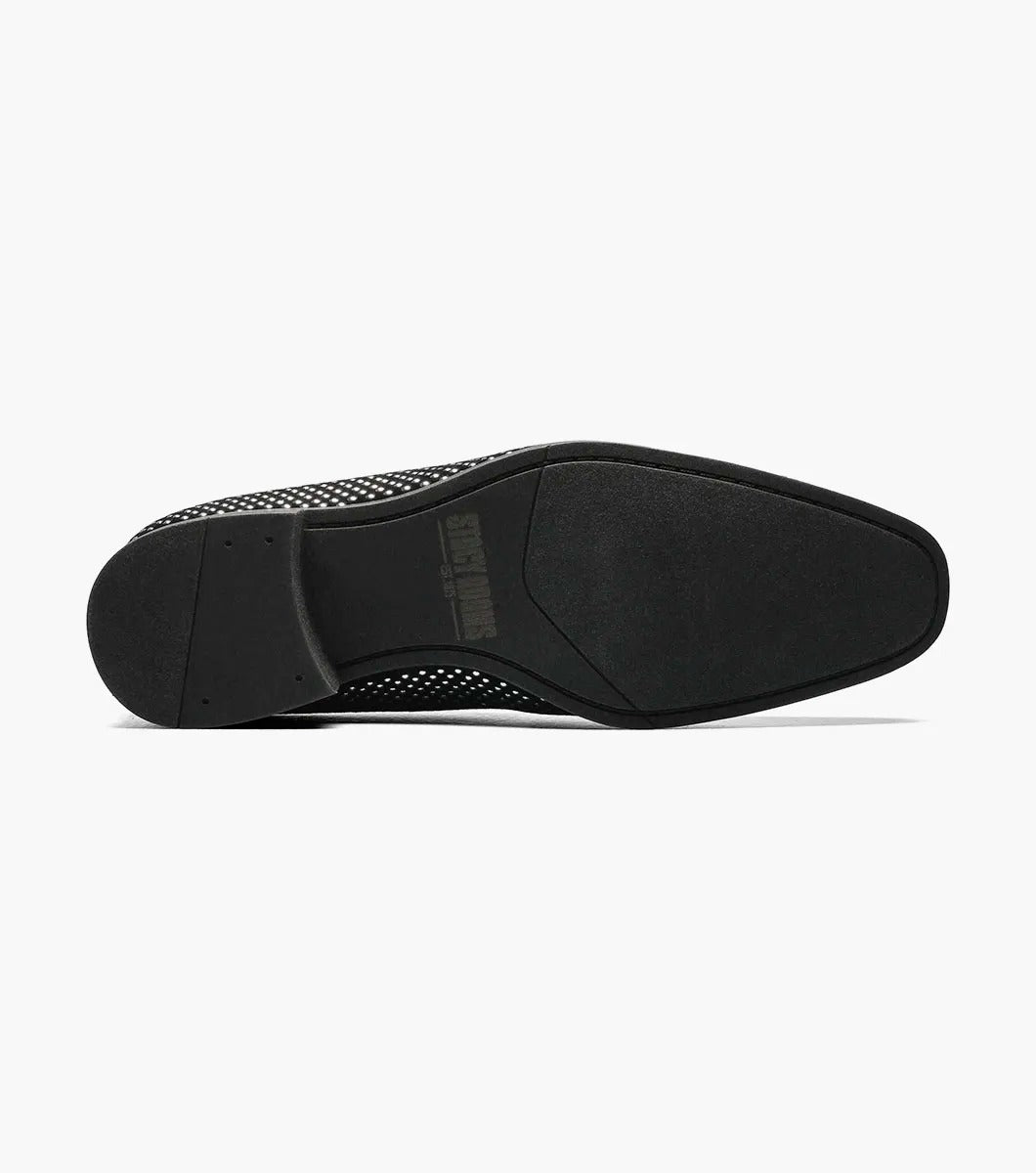 The STACY ADAMS SWAGGER Studded Slip On in black and silver, model 25228-042, is a loafer featuring striking silver studs and the Stacy Adams crest on the upper, exuding a sense of understated elegance.
