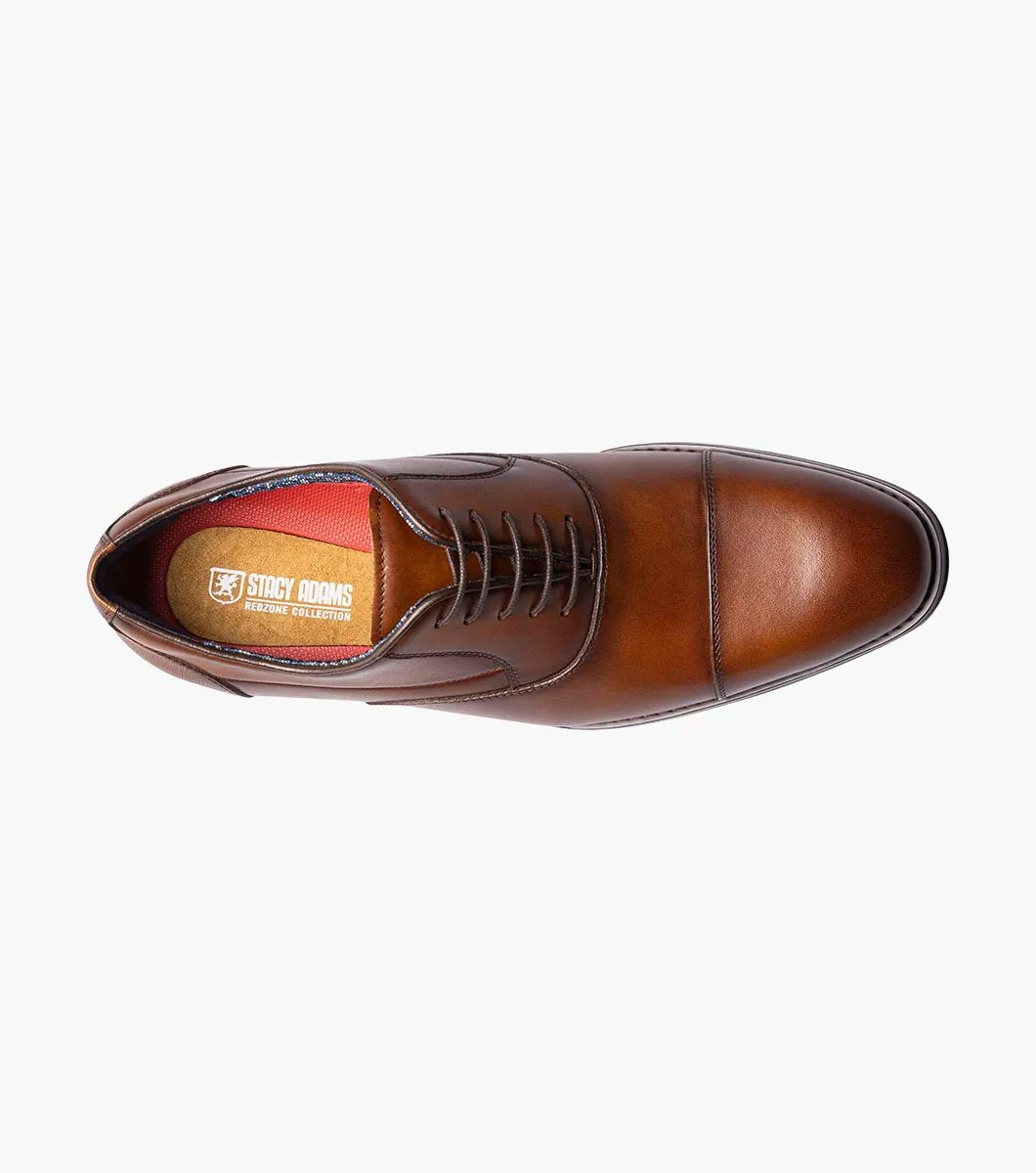 The STACY ADAMS Kallum Cap Toe Oxford in Cognac (25568-221) is a brown men's dress shoe with a cushioned footbed and dark laces, shown on a white background.