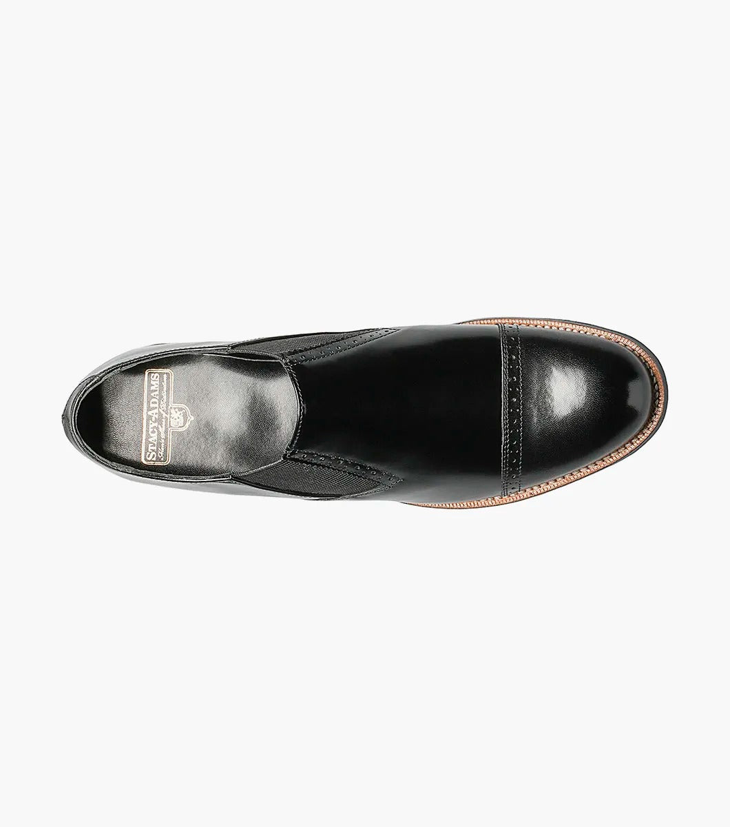 The Stacy Adams MADISON Cap Toe Slip On in black, designated as style number 00017-01, features a sophisticated cap-toe design with elastic side panels, complemented by a leather sole and sleek low heel.
