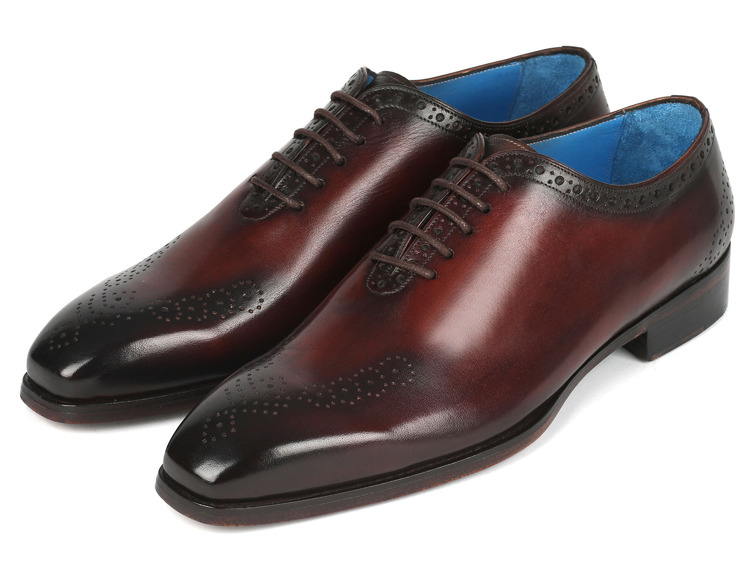 A pair of Paul Parkman Goodyear Welted Punched Oxfords in brown, crafted from intricately hand-painted calfskin featuring decorative perforations, lace-up closures, and a vibrant blue lining.
