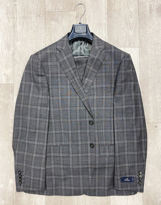 A Canaletto Grey/Plum Plaid Dolcetto Modern Fit Suit by Reda Cloth, crafted with premium Italian wool, hangs elegantly on a wooden hanger against a light wooden background.