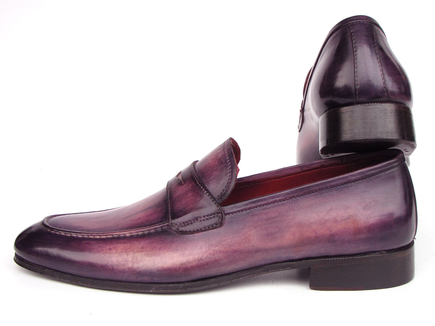 A pair of Paul Parkman Men's Purple Patina Penny Loafers - 17PRP33, crafted from hand-painted leather with a strap across the front, displayed on a white background.
