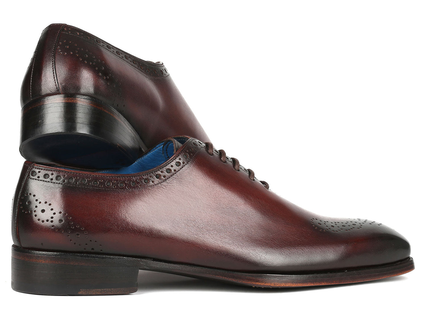 A pair of Paul Parkman Goodyear Welted Punched Oxfords in brown, crafted from intricately hand-painted calfskin featuring decorative perforations, lace-up closures, and a vibrant blue lining.