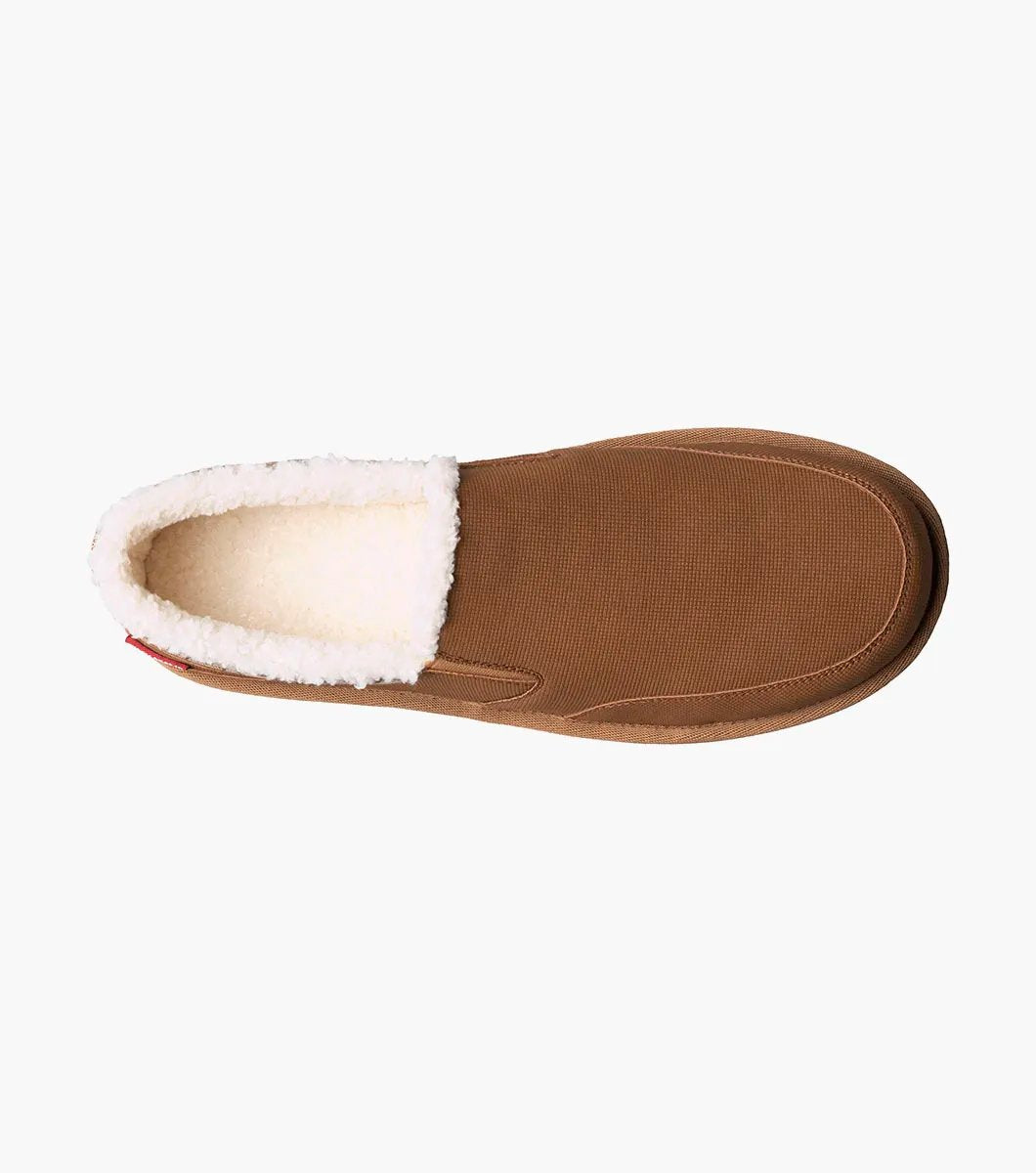 The Stacy Adams Coze Moc Toe Slip On in Tan Multi features a textured upper, plush faux shearling lining, and flat rubber sole, shown on a white background.