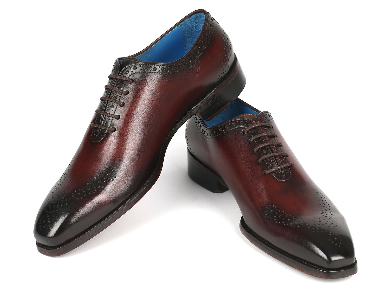 A pair of Paul Parkman Goodyear Welted Punched Oxfords in brown, crafted from intricately hand-painted calfskin featuring decorative perforations, lace-up closures, and a vibrant blue lining.