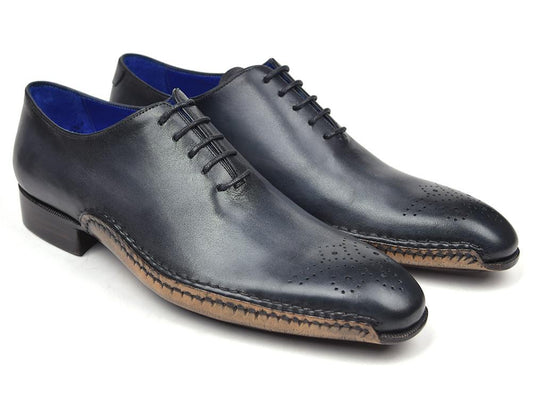 The Paul Parkman Opanka Construction Oxfords in Anthracite Gray, model 86A5-ANT, are showcased against a plain backdrop. These shoes feature a medallion toe design and striking blue inner lining. The hand-painted leather enhances the elegance of these refined oxfords.