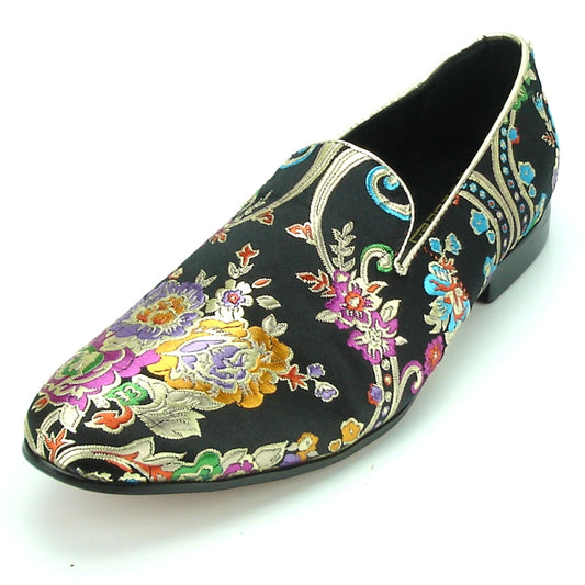 The FI-7151 Black Fiesso by Aurelio Garcia from Fiesso is a stylish slip-on loafer with a black background and a floral pattern showcasing vibrant colors such as purple, gold, and green. It combines style with comfort thanks to its premium leather lining.