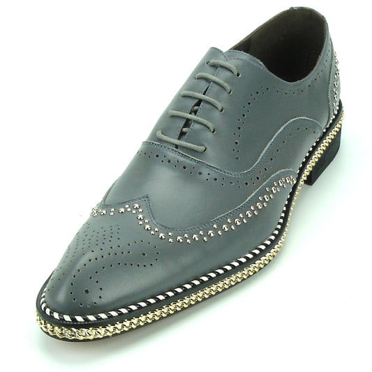 The FI-7201 Grey Fiesso by Aurelio Garcia Shoes from the brand Fiesso is a stylish leather brogue featuring a grey leather upper adorned with decorative perforations, metallic studs along the edges, and braided detailing on the sole.