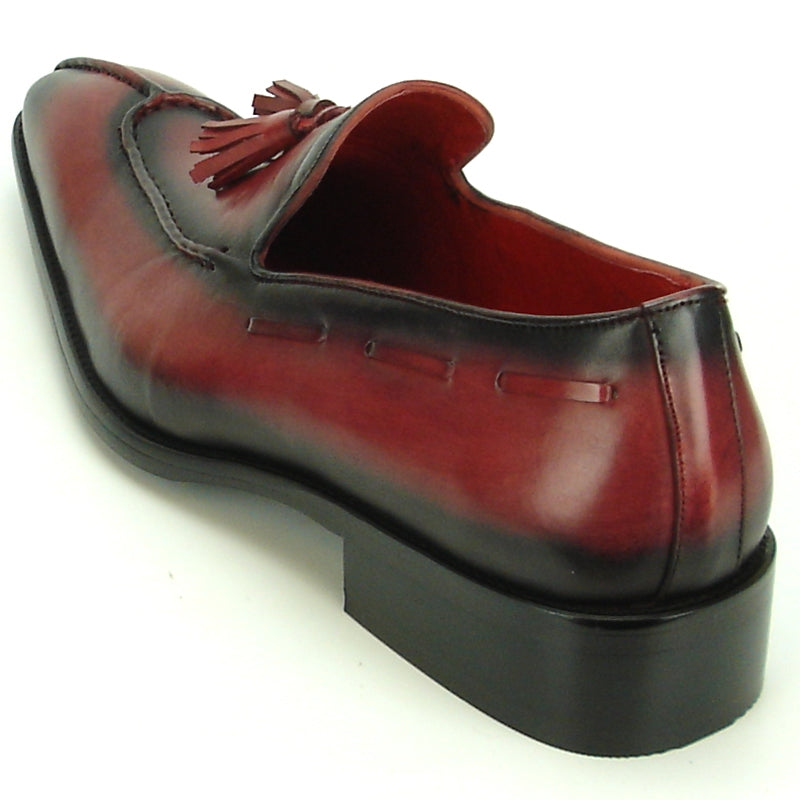 The FI-8701 Burgundy Encore by Fiesso is a polished leather loafer with a maroon hue, black gradient, and tassel detail on the instep that exemplifies high-fashion footwear, set against a plain background.