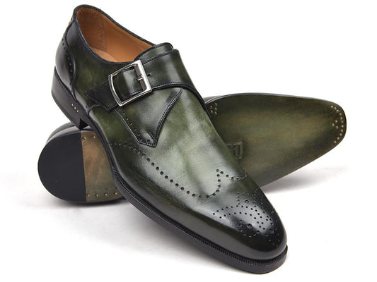 A pair of Paul Parkman Wingtip Single Monkstraps Green - 98F54-GRN shoes, crafted in green leather with polished perforated detailing and a sleek buckle, features one shoe upright while the other lies gracefully on its side.