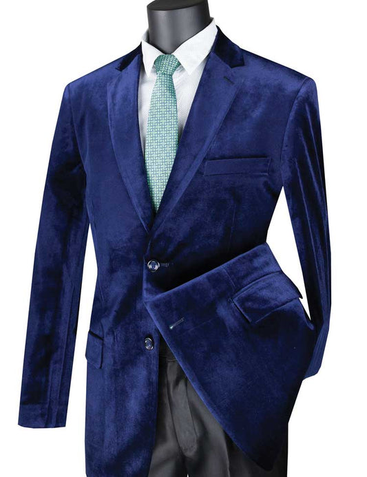 Mannequin dressed in a Vinci Suits Velvet Regular Fit Fashion Jacket (Sapphire) B-27, with a blue velvet suit and green tie over a white shirt, holding the matching jacket.