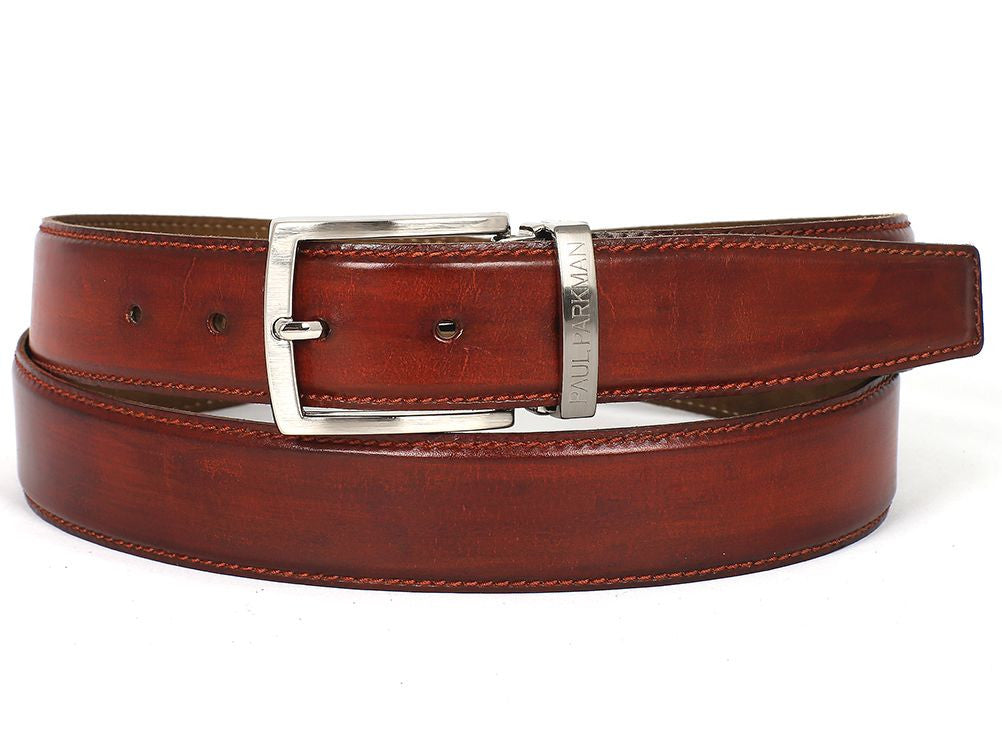 A customized Paul Parkman leather belt, hand-painted in a reddish-brown hue from Italian calfskin, featuring a silver buckle with an engraved logo and visible stitching, displayed coiled.