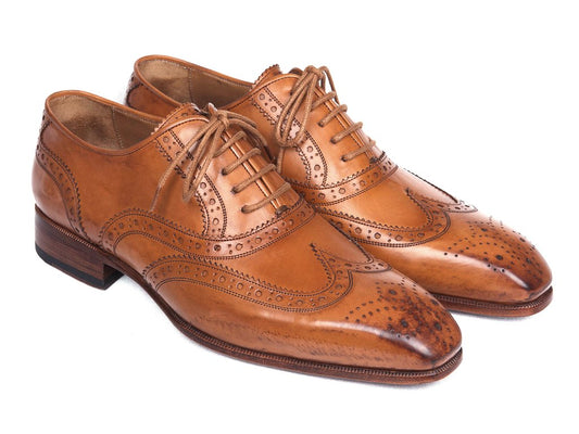 The Paul Parkman Wingtip Oxfords Cognac - 5447-CGN shoes, featuring intricate brogue detailing and laces, are placed side by side on a white background.