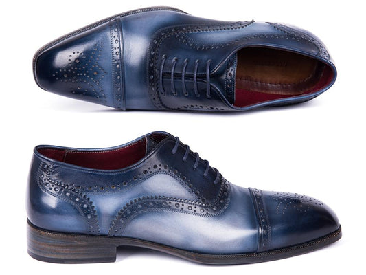 The Paul Parkman Cap Toe Oxfords Blue & Navy - 024-NVYBLU, crafted by Paul Parkman, are hand-painted leather shoes with decorative perforations and laces, elegantly displayed on a white background.