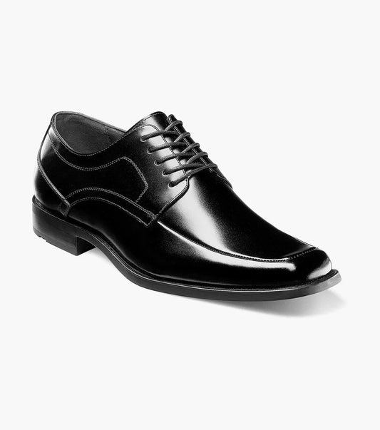 The Stacy Adams Calhoun Moc Toe Oxford (20117-001) is a black leather men's dress shoe with laces, a slightly pointed toe, and low heel by STACY ADAMS, shown on a white background.