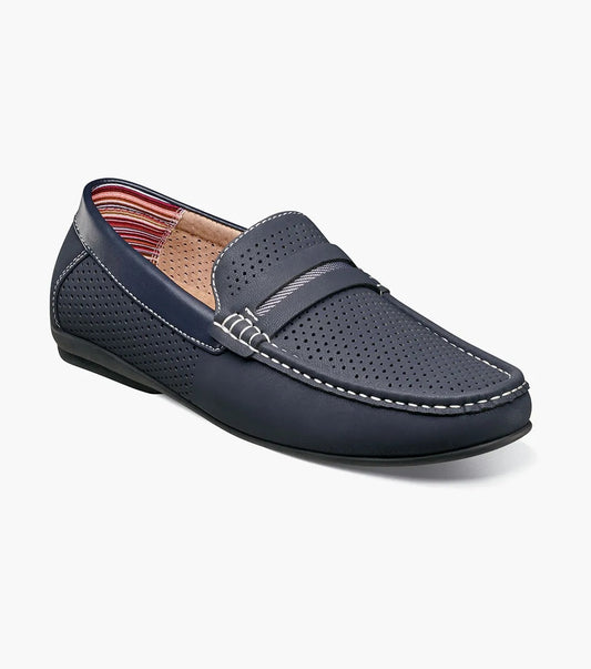 The STACY ADAMS Corby Moc Toe Saddle Slip On (25513-410) is a navy men’s loafer with perforated detail, white stitching, a subtle strap, and leather linings—perfect for casual warm-weather wear, shown on a white background.