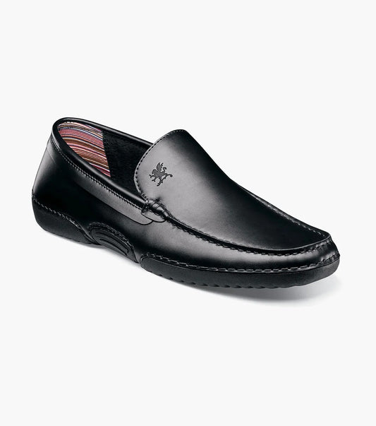 The STACY ADAMS Del Moc Toe Loafer (25533-001) in black features visible stitching, a subtle logo on the upper, and a striped inner lining, shown on a white background.