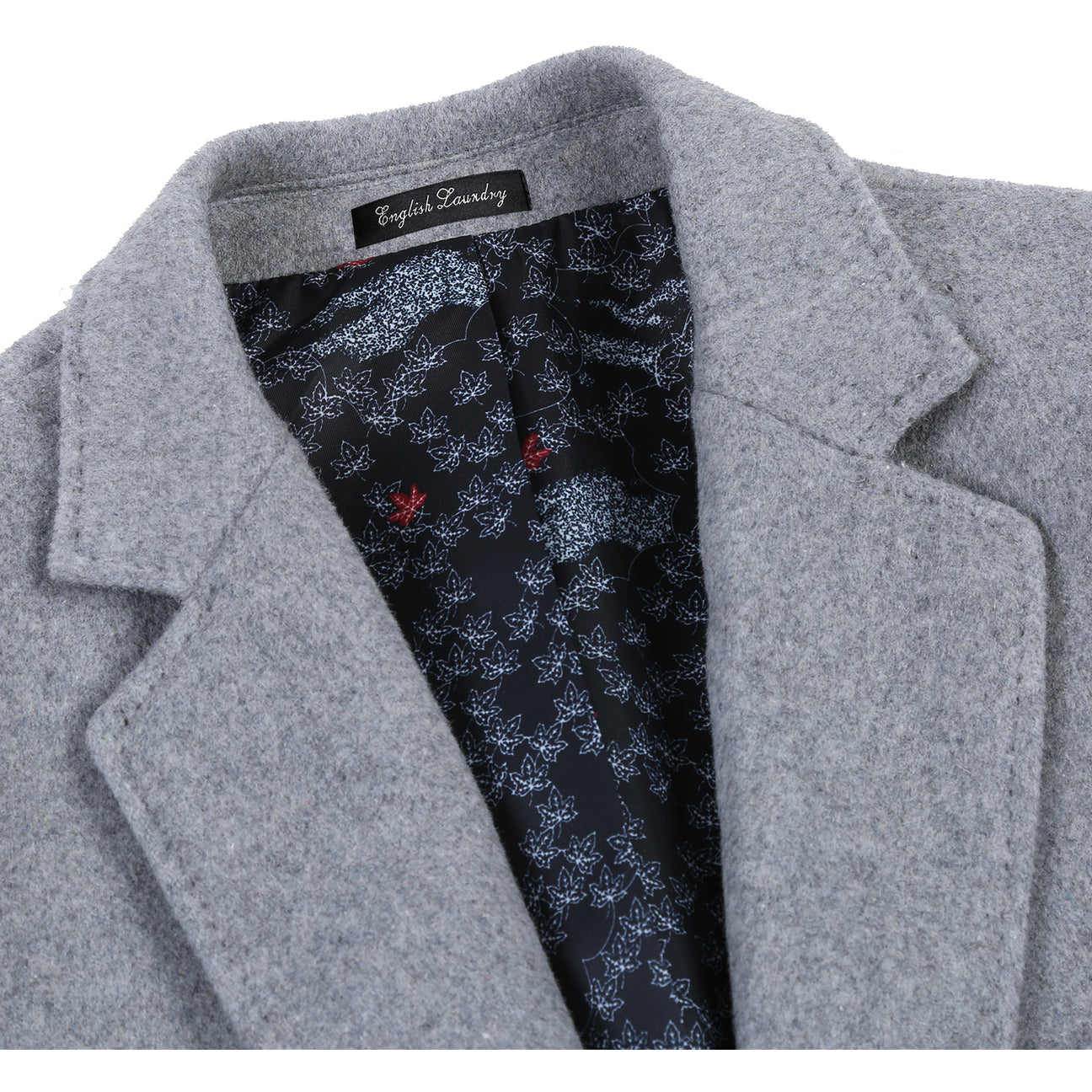 The ENGLISH LAUNDRY Wool Blend Breasted Light Gray Top Coat EL53-01-092 by English Laundry is a stylish single-breasted overcoat featuring three buttons and notched lapels. It pairs well with a white shirt and navy polka dot tie, making it the perfect versatile topcoat for any occasion.
