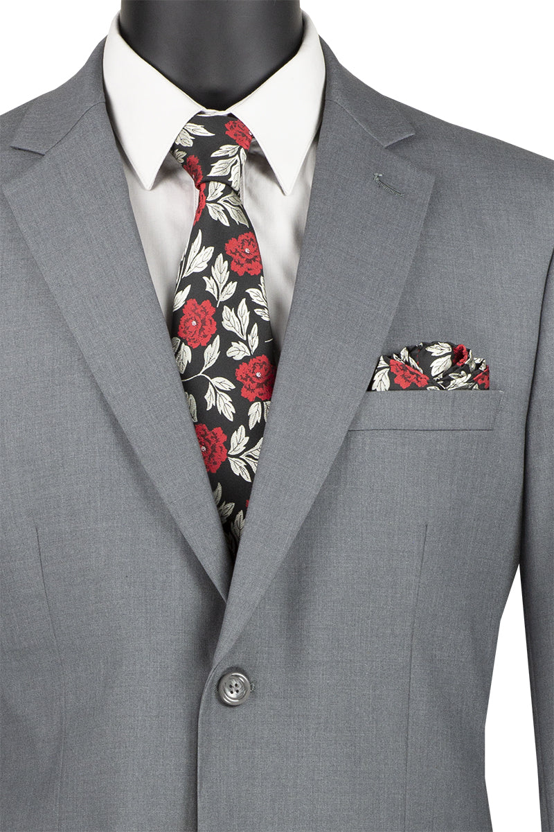 Displayed on a mannequin, the Vinci Suits 2 Piece Suit F-2C900 in medium gray features a floral tie and matching pocket square. Designed for comfort with a 2″ adjustable waistband, it offers a luxurious wool feel, perfect for elevating any occasion.