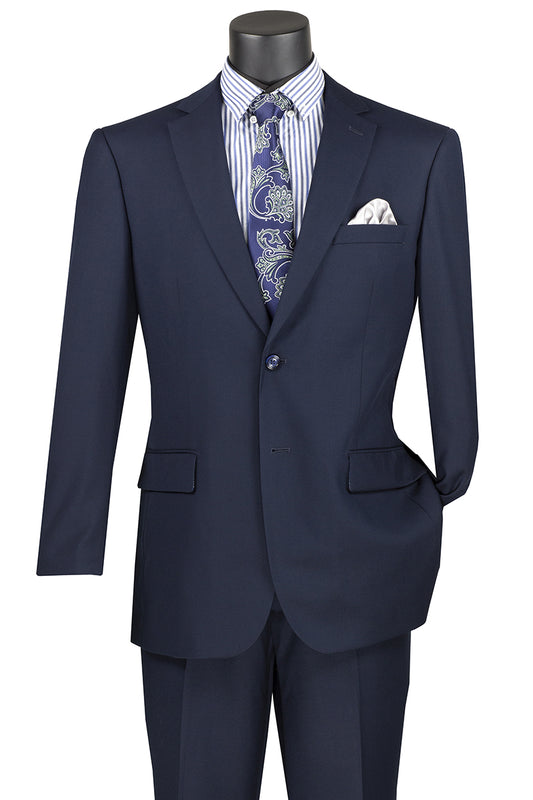 On display is a Vinci Suits 2 Piece Navy Suit (F-2C900) with a notch lapel and wool feel, elegantly paired with a blue and white striped shirt, paisley tie, and crisp white pocket square.
