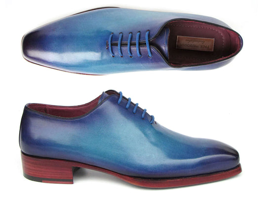 Two Paul Parkman Goodyear Welted Wholecut Oxfords in a blue and turquoise gradient color with a polished finish. One shoe is positioned upright while the other is on its side, highlighting the craftsmanship of the sole.