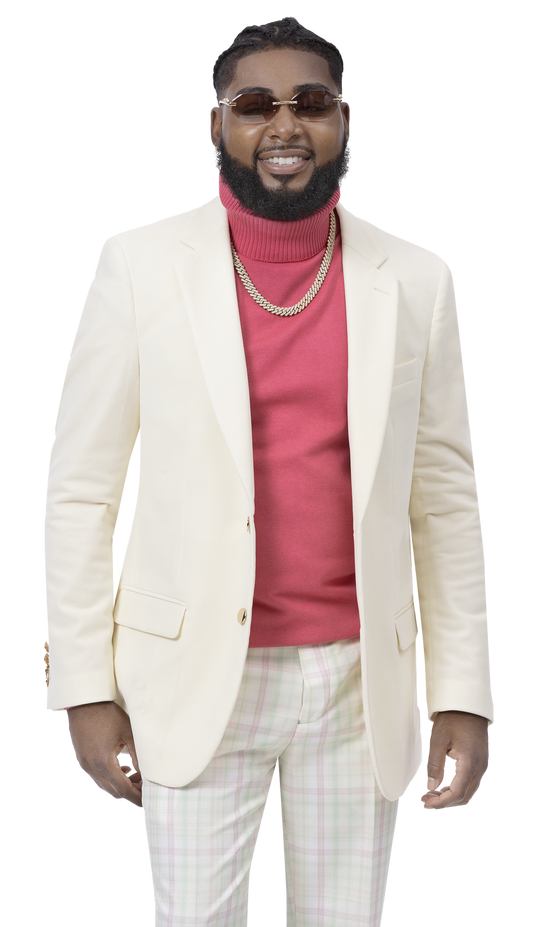 A man wearing the EJ Samuel Cream Velvet Blazer J134, featuring gold buttons, a red turtleneck, and plaid pants, smiles while standing with his hands by his sides.