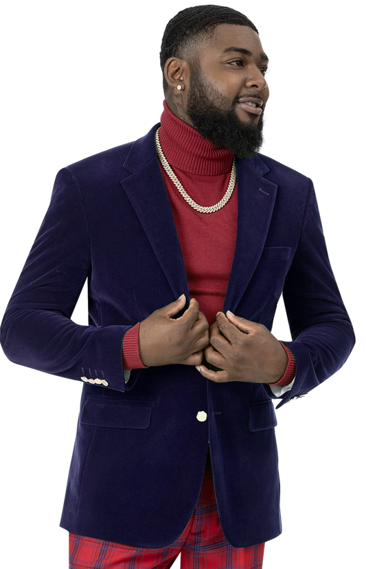 A man dressed in the EJ Samuel Royal Velvet Blazer J134 from EJ SAMUEL, featuring gold buttons, paired with a red turtleneck and plaid pants, accessorized with a gold chain necklace.