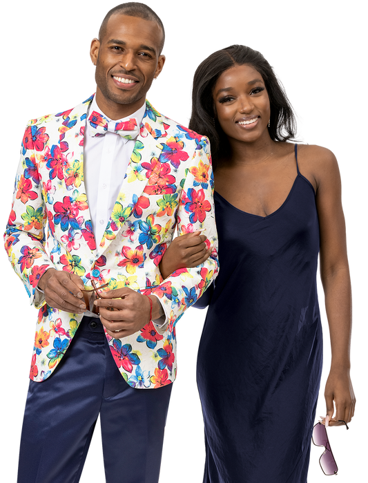 An individual wearing the EJ Samuel Flower Blazer J163 and a bow tie stands arm-in-arm with a woman in a navy dress holding sunglasses, highlighting their impeccable fashion sense with EJ SAMUEL attire.