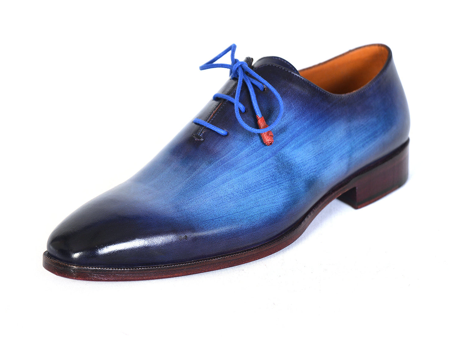 The Paul Parkman Men's Plain Toe Wholecut Oxfords in Blue, also known as model 755-BLU, boast a striking hand-painted gradient effect. These exquisite handmade shoes feature elegant blue laces and a classic wooden heel, embodying unrivaled craftsmanship and style.
