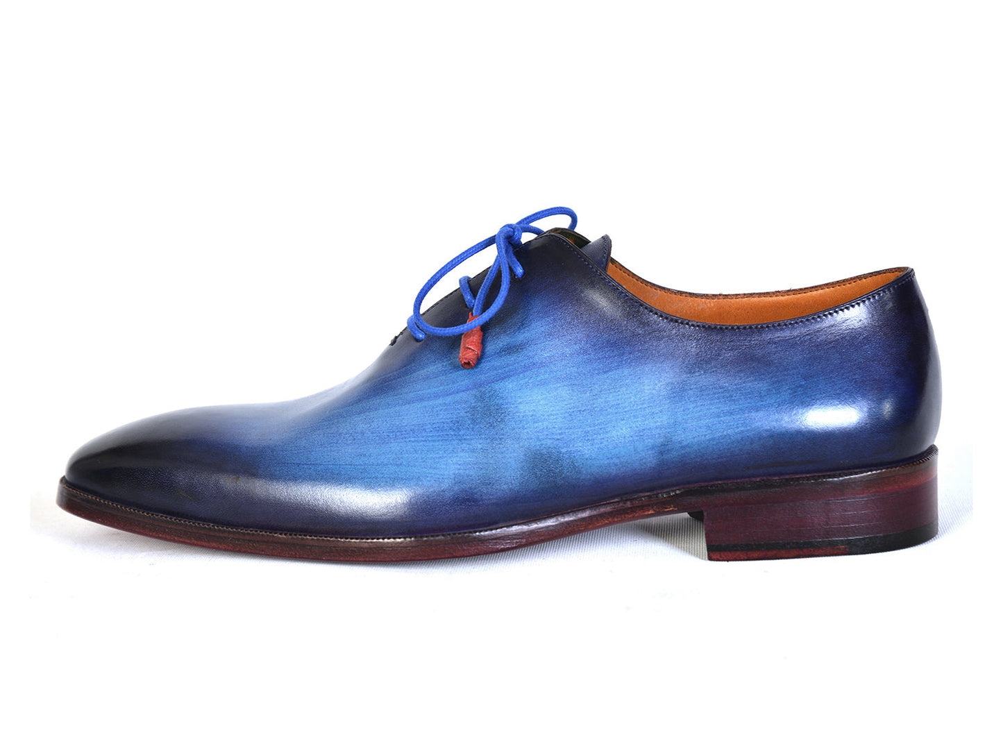 The Paul Parkman Men's Plain Toe Wholecut Oxfords in Blue, also known as model 755-BLU, boast a striking hand-painted gradient effect. These exquisite handmade shoes feature elegant blue laces and a classic wooden heel, embodying unrivaled craftsmanship and style.