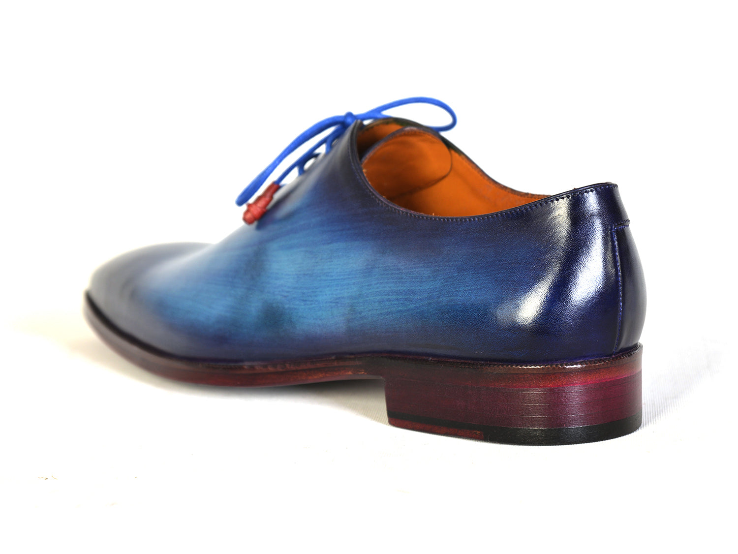 The Paul Parkman Men's Plain Toe Wholecut Oxfords in Blue, also known as model 755-BLU, boast a striking hand-painted gradient effect. These exquisite handmade shoes feature elegant blue laces and a classic wooden heel, embodying unrivaled craftsmanship and style.
