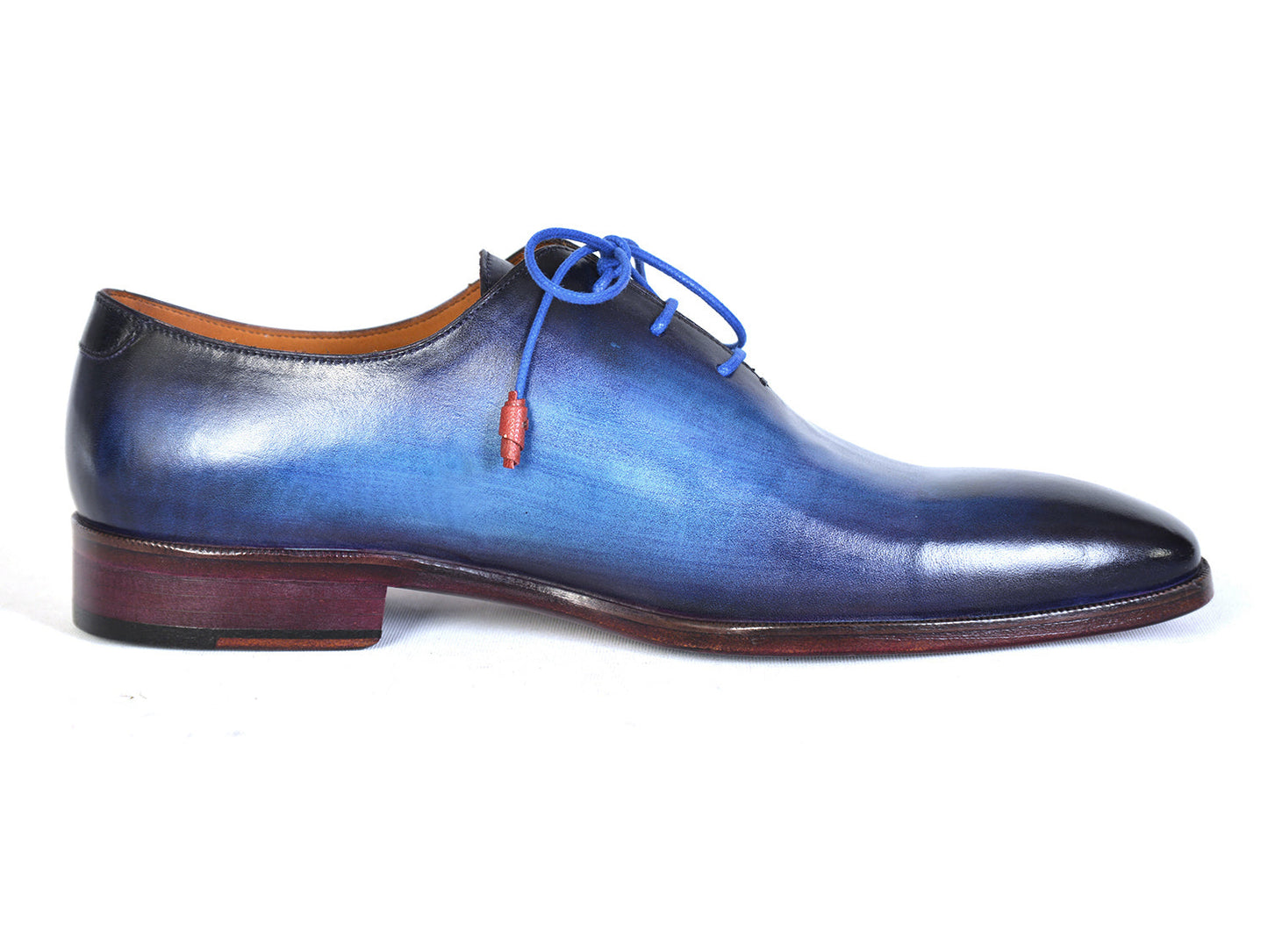 The Paul Parkman Men's Plain Toe Wholecut Oxfords in Blue, also known as model 755-BLU, boast a striking hand-painted gradient effect. These exquisite handmade shoes feature elegant blue laces and a classic wooden heel, embodying unrivaled craftsmanship and style.