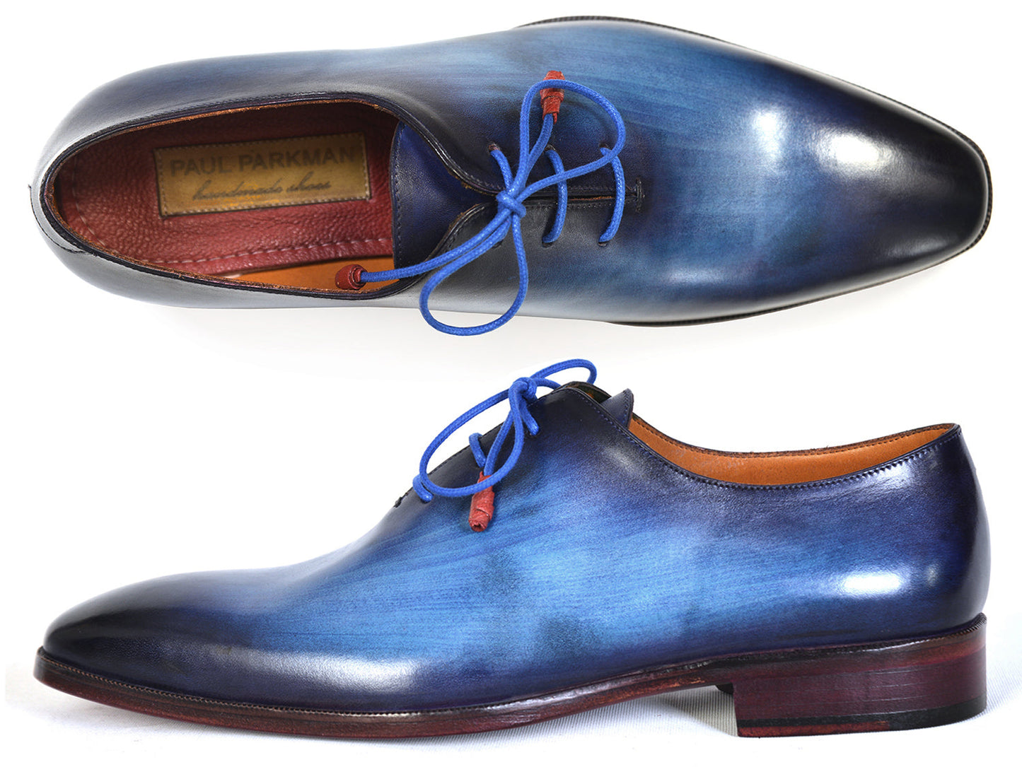 The Paul Parkman Men's Plain Toe Wholecut Oxfords in Blue, also known as model 755-BLU, boast a striking hand-painted gradient effect. These exquisite handmade shoes feature elegant blue laces and a classic wooden heel, embodying unrivaled craftsmanship and style.
