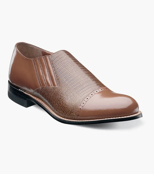 Stacy Adams presents the MADISON Cap Toe Slip On in tan, showcasing a leather upper with a textured pattern and brogue details, finished with a low black heel.