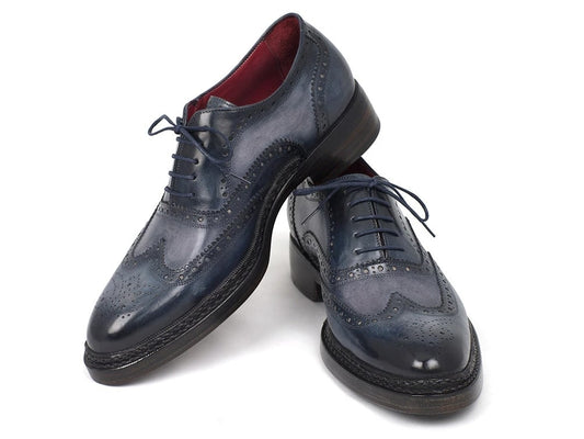 A pair of Paul Parkman Triple Leather Sole Wingtip Brogues in blue, crafted from hand-painted leather with intricate perforations and laces, showcased against a white background.