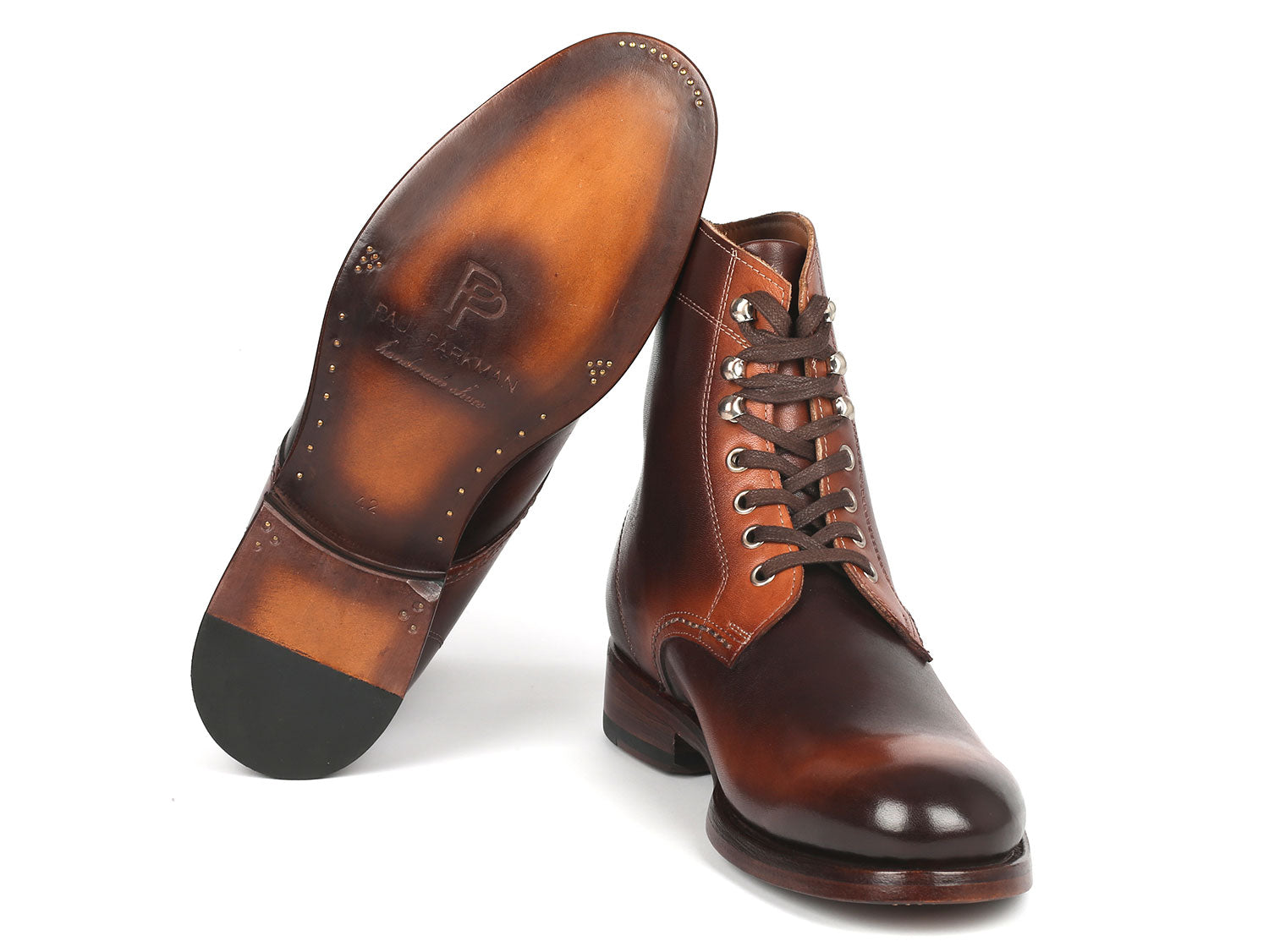 The Paul Parkman Men's Brown Burnished Leather Boots - 824BRW73 showcase a polished finish with silver eyelets and stacked heels, crafted from hand-painted calfskin, against a white background.