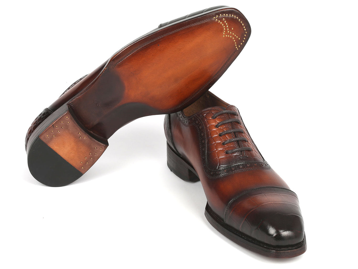 The Paul Parkman Goodyear Welted Cap Toe Oxfords Brown - 9482-BRW showcases polished brown leather with black toe caps, complete with laces and decorative stitching. It proudly features a handcrafted fiddle waist design and Goodyear welt construction for enhanced durability, elegantly displayed in a stacked position.