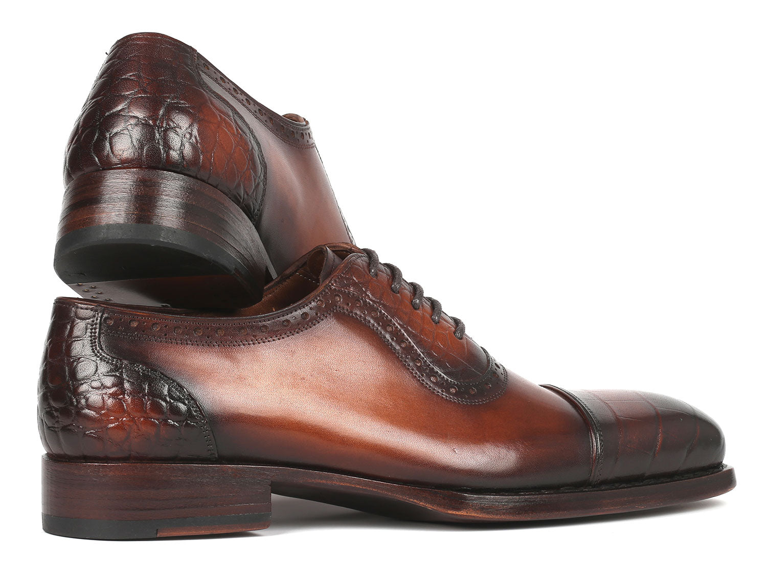 The Paul Parkman Goodyear Welted Cap Toe Oxfords Brown - 9482-BRW showcases polished brown leather with black toe caps, complete with laces and decorative stitching. It proudly features a handcrafted fiddle waist design and Goodyear welt construction for enhanced durability, elegantly displayed in a stacked position.
