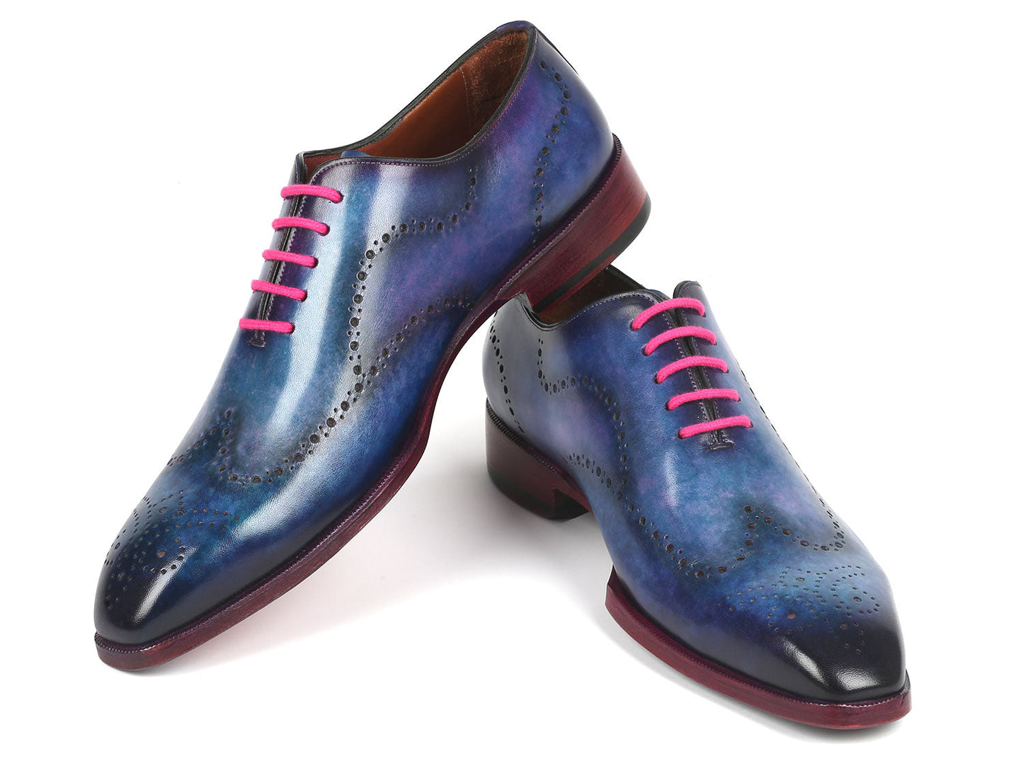 A pair of Paul Parkman's Men's Wingtip Oxfords in Parliament Blue leather, adorned with pink laces and featuring wingtip perforated decoration, is displayed against a white background.