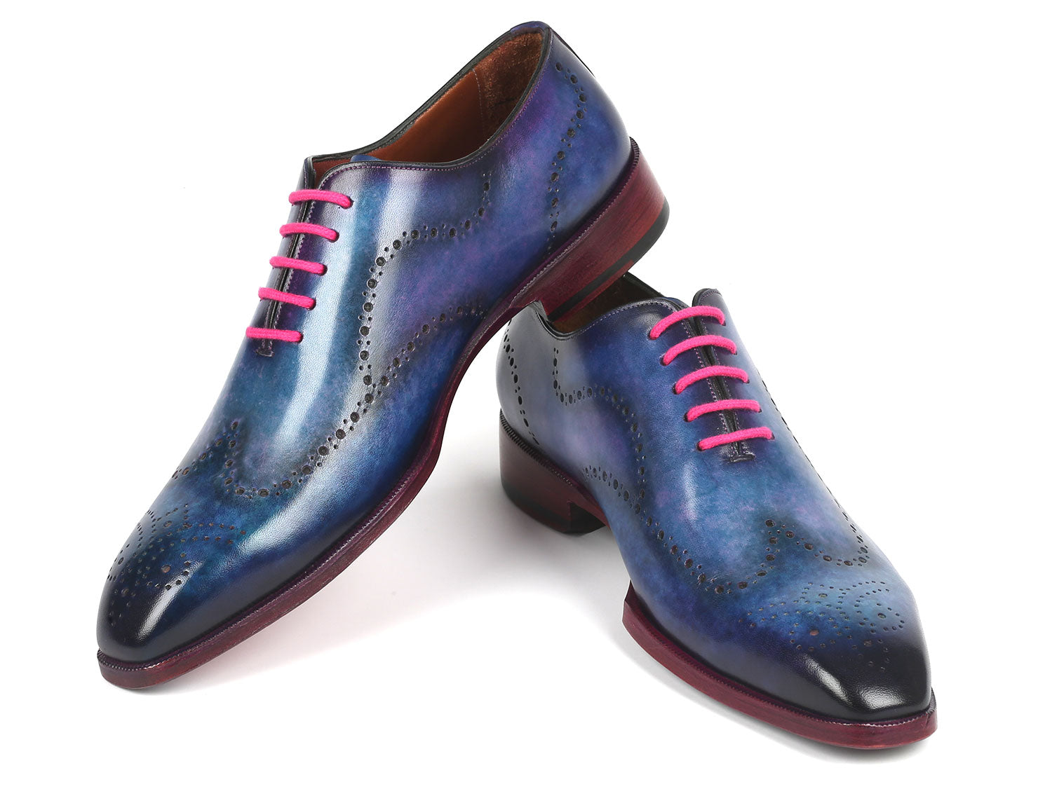 A pair of Paul Parkman's Men's Wingtip Oxfords in Parliament Blue leather, adorned with pink laces and featuring wingtip perforated decoration, is displayed against a white background.