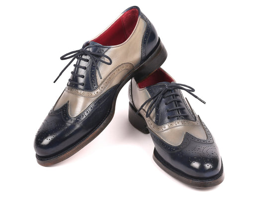 Paul Parkman presents the Navy & Gray Wingtip Oxfords, crafted with attention to detail using Goodyear welted construction. These men's handmade shoes feature two-tone leather in navy and gray, a striking red inner lining, intricate perforations, and are completed with elegant laces for enduring sophistication.