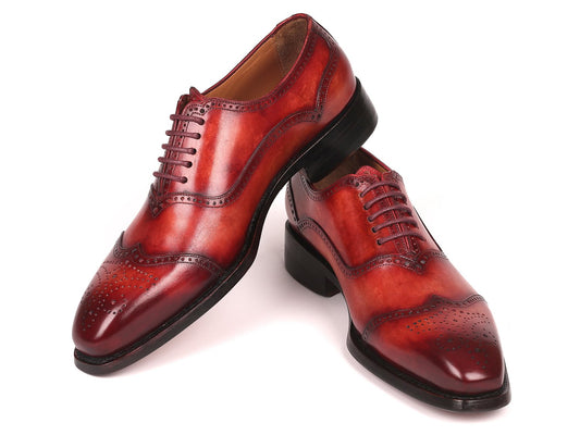 A pair of Paul Parkman Goodyear Welted Oxford Shoes Reddish Brown - 094-RDH, featuring a sleek design with laces and intricate perforations in polished reddish brown leather, expertly crafted for durability.