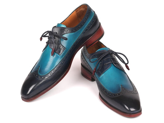 Introducing the Paul Parkman Blue Dual Tone Wingtip Derby Shoes - 6931BLU, a sophisticated pair of men's dress shoes meticulously crafted from hand-painted calfskin. These elegant shoes feature striking blue leather, contrasting black toe caps, exquisite brogue detailing, and distinctive dark red soles, making them ideal for those who value elegance with a unique flair.