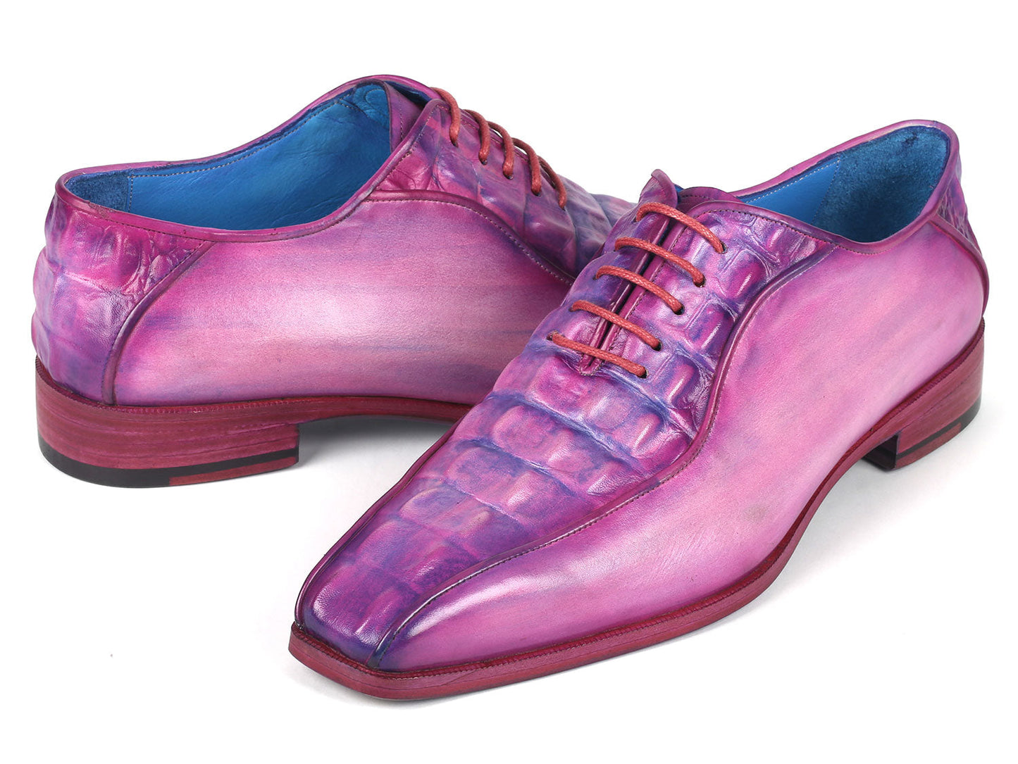 Introducing the Paul Parkman Purple Croco Textured Leather Bicycle Toe Oxfords - 94-277: a pair of handmade shoes crafted from shiny, lizard skin leather in a striking purple hue. Designed with a bicycle toe, these luxurious oxfords feature intricate blue lining and vibrant pink laces, elegantly displayed against a clean, white background.