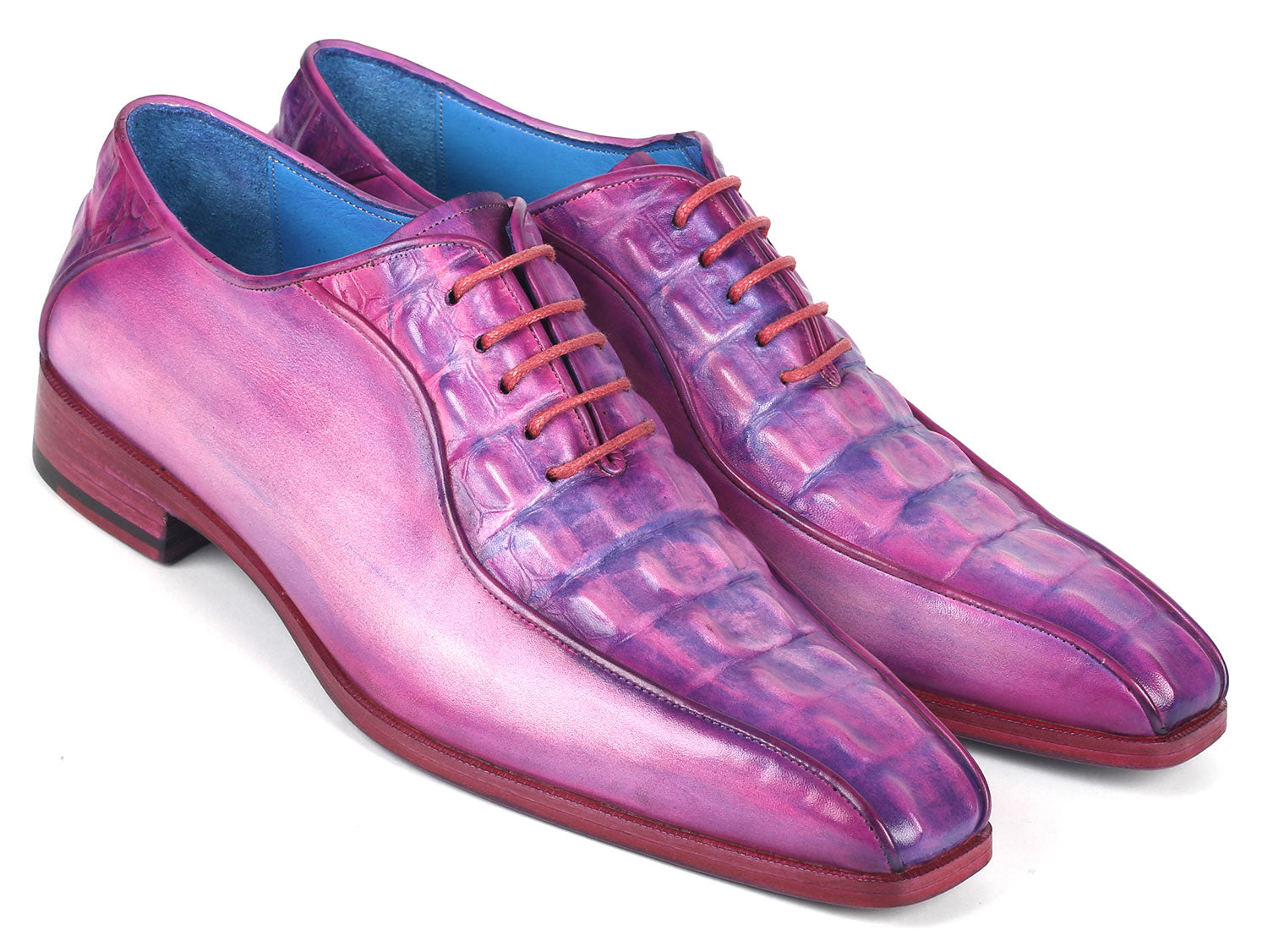 Introducing the Paul Parkman Purple Croco Textured Leather Bicycle Toe Oxfords - 94-277: a pair of handmade shoes crafted from shiny, lizard skin leather in a striking purple hue. Designed with a bicycle toe, these luxurious oxfords feature intricate blue lining and vibrant pink laces, elegantly displayed against a clean, white background.