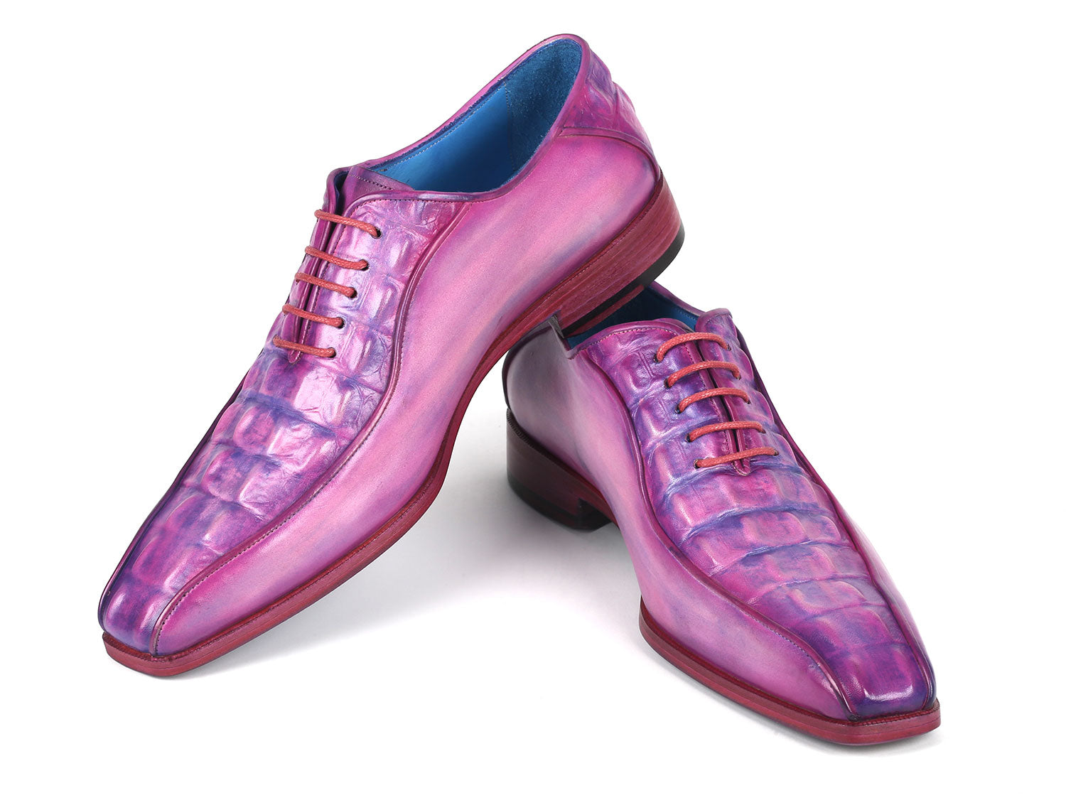 Introducing the Paul Parkman Purple Croco Textured Leather Bicycle Toe Oxfords - 94-277: a pair of handmade shoes crafted from shiny, lizard skin leather in a striking purple hue. Designed with a bicycle toe, these luxurious oxfords feature intricate blue lining and vibrant pink laces, elegantly displayed against a clean, white background.