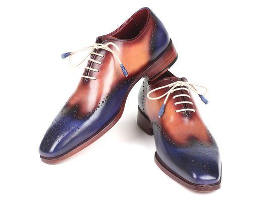 Introducing the Paul Parkman Blue & Camel Wingtip Oxfords - 097BX11: a pair of stylish, handmade shoes crafted from hand-painted leather showcasing a gradient pattern of blue, brown, and burgundy. These made-to-order brogues feature decorative perforations and white laces.