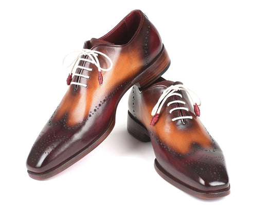The Paul Parkman Bordeaux & Camel Wingtip Oxfords - 097BY30 are featured against a white background, showcasing their brown leather composition with white laces, a gradient pattern, handmade brogue detailing, and a durable leather sole.