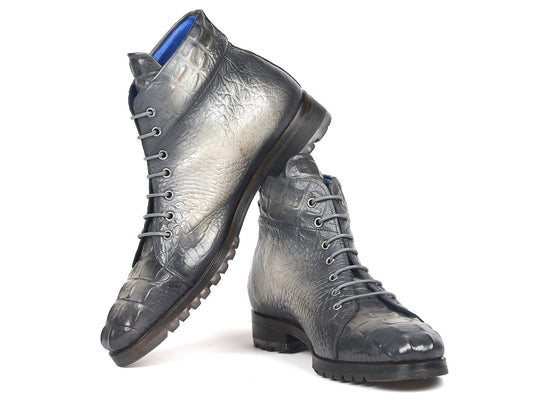 The Paul Parkman Gray Croco Embossed Leather Boots, model 12811-GRY, are exquisitely designed with hand-painted gray leather and a croco-embossed pattern. They feature lace-up fronts and sturdy soles, with one boot stylishly propped against the other.